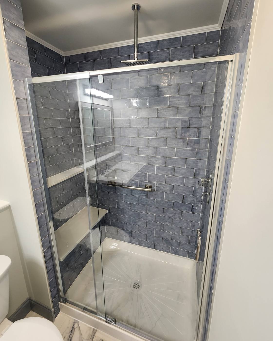 Navy tile walk-in shower with rain head and glass doors