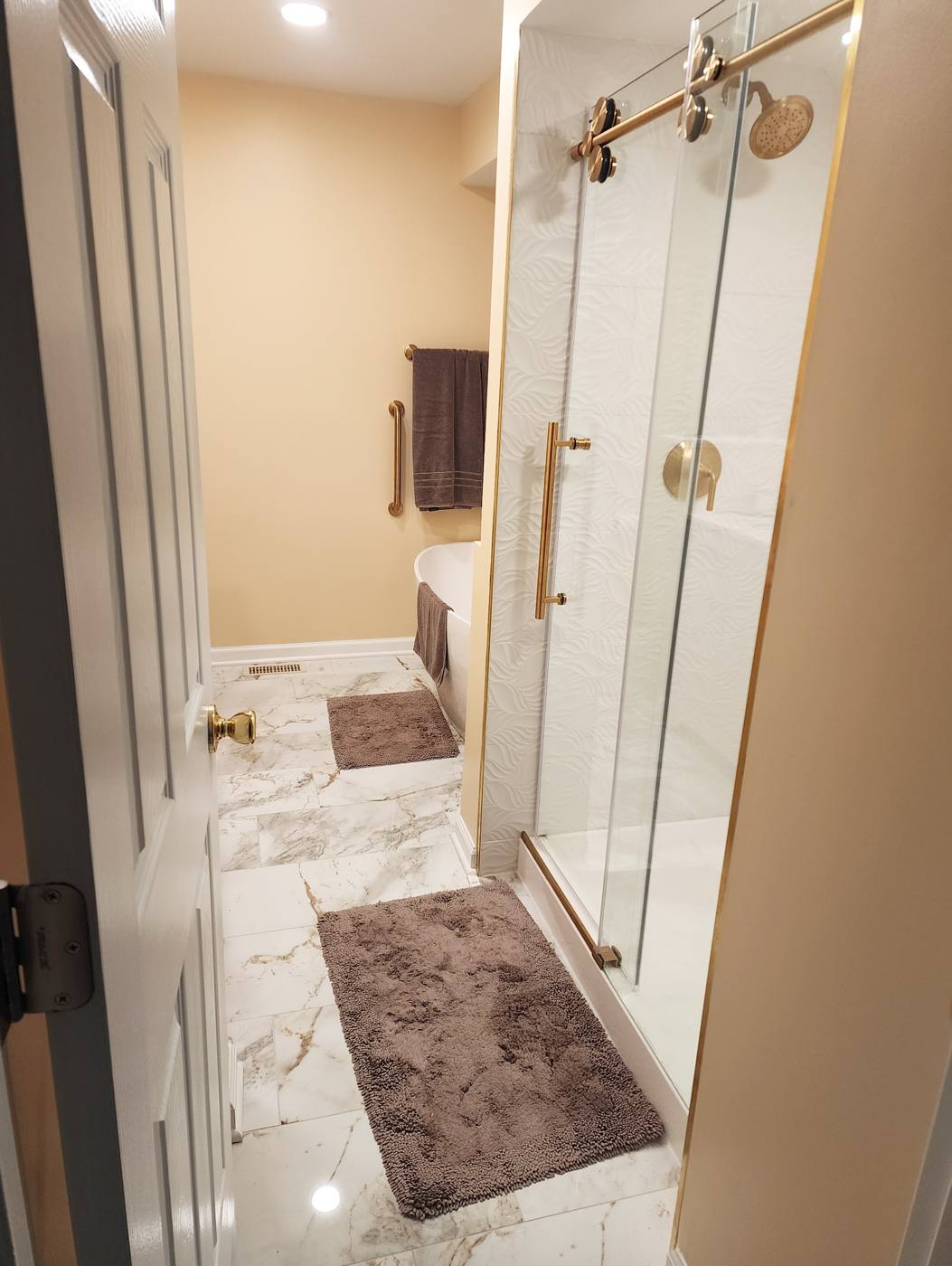 Sliding glass shower with brushed-gold hardware
