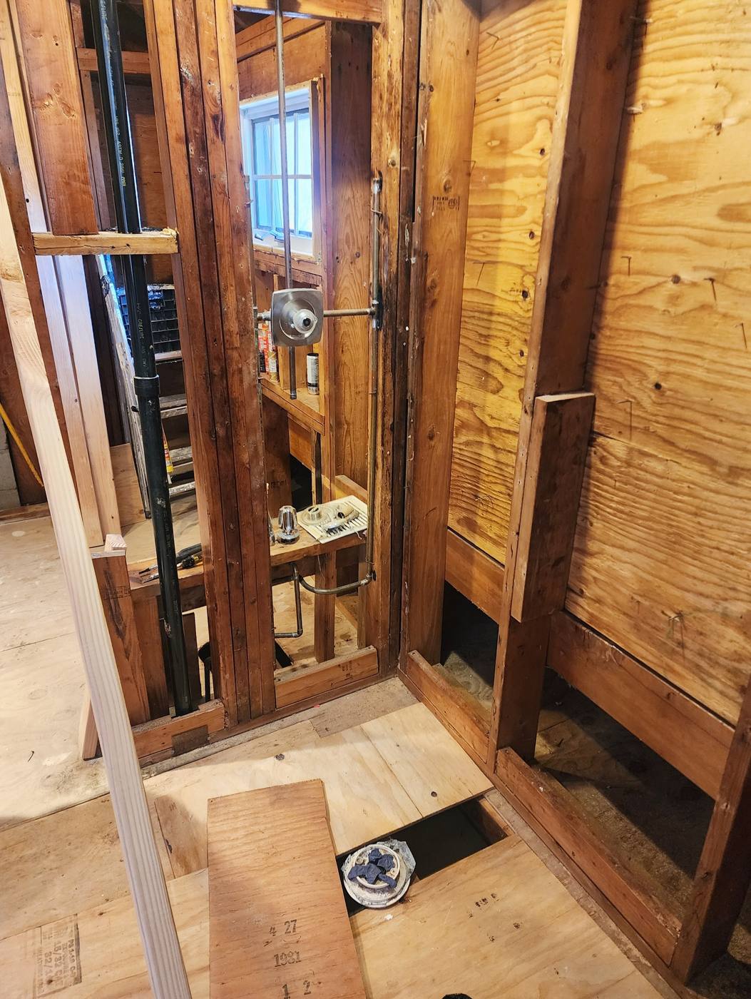 Bathroom gutted to the studs with new plumbing rough-in ready for inspection