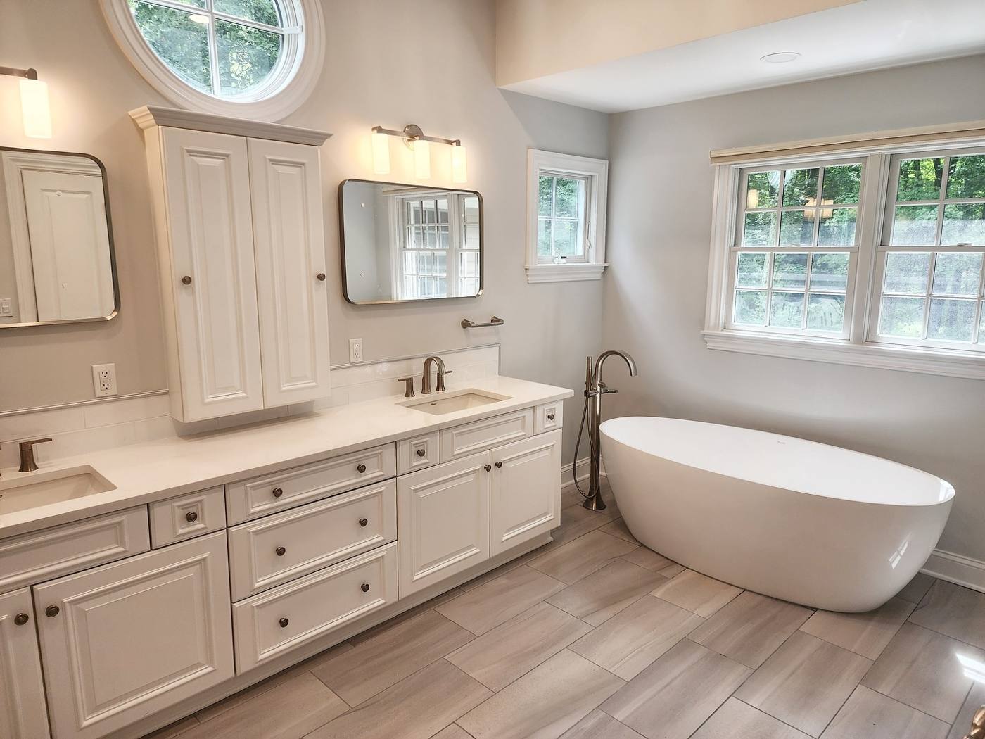 Primary bath with double vanity, linen tower and freestanding tub