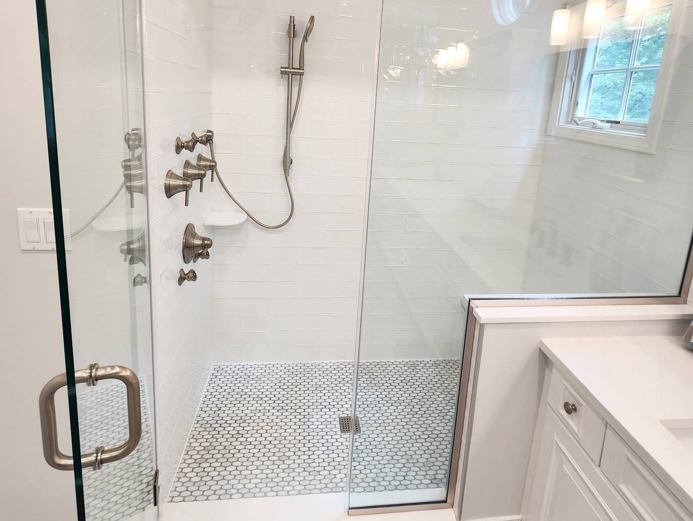 Walk-in shower with subway tile and marble mosaic floor
