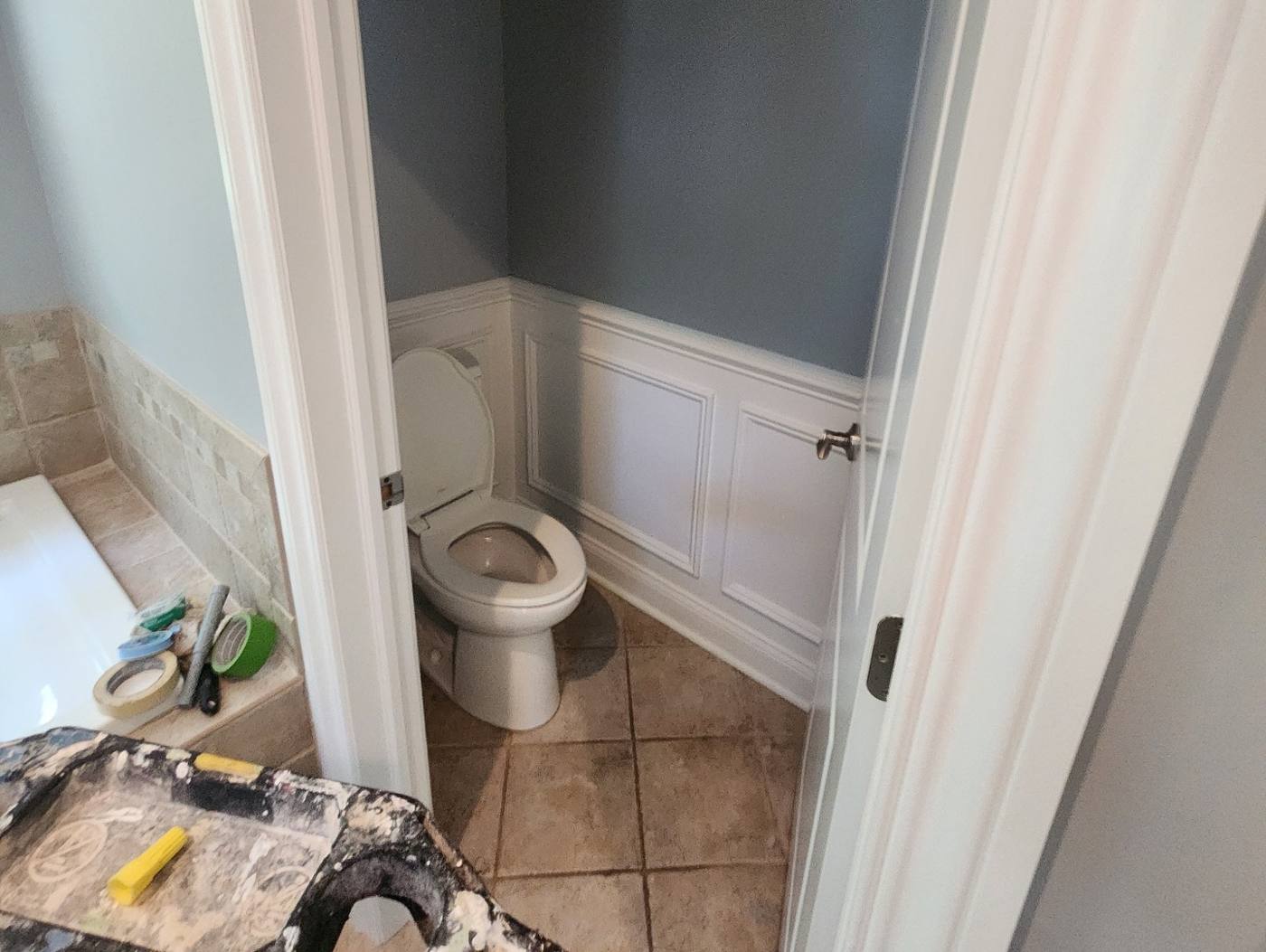 Powder room mid-demo with old brown tile floor