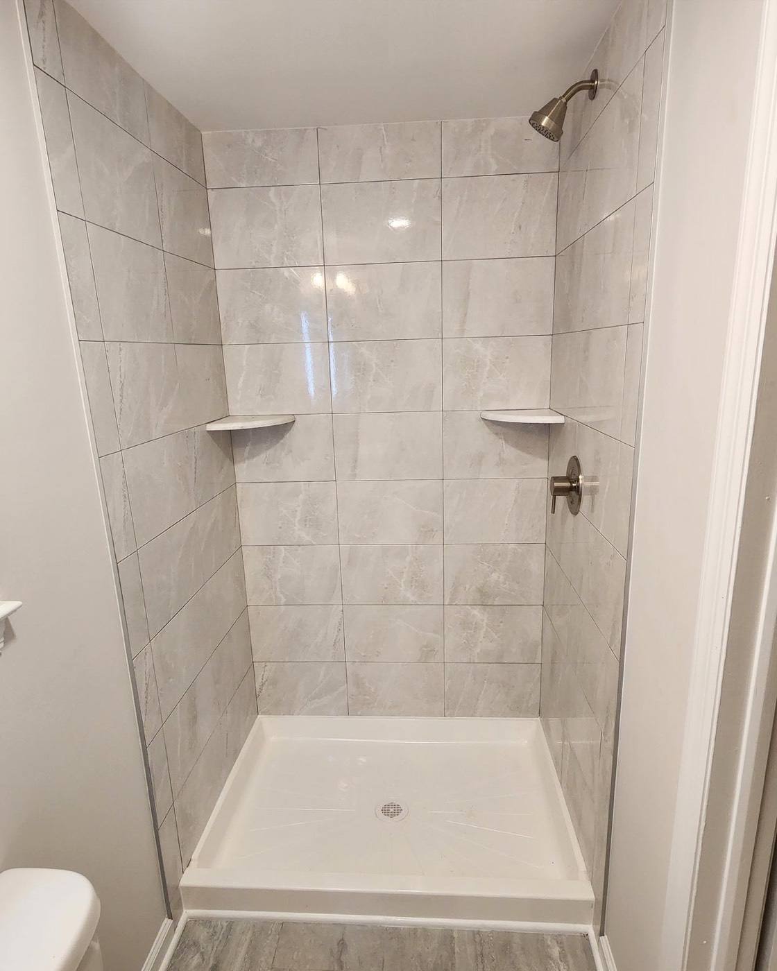 Walk-in shower with large gray marble-look tile