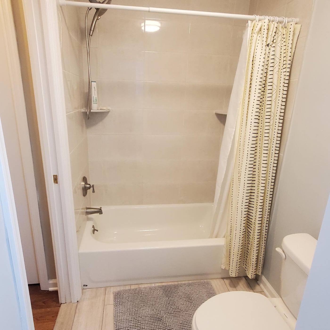 Tub with tile surround and wood-look floor
