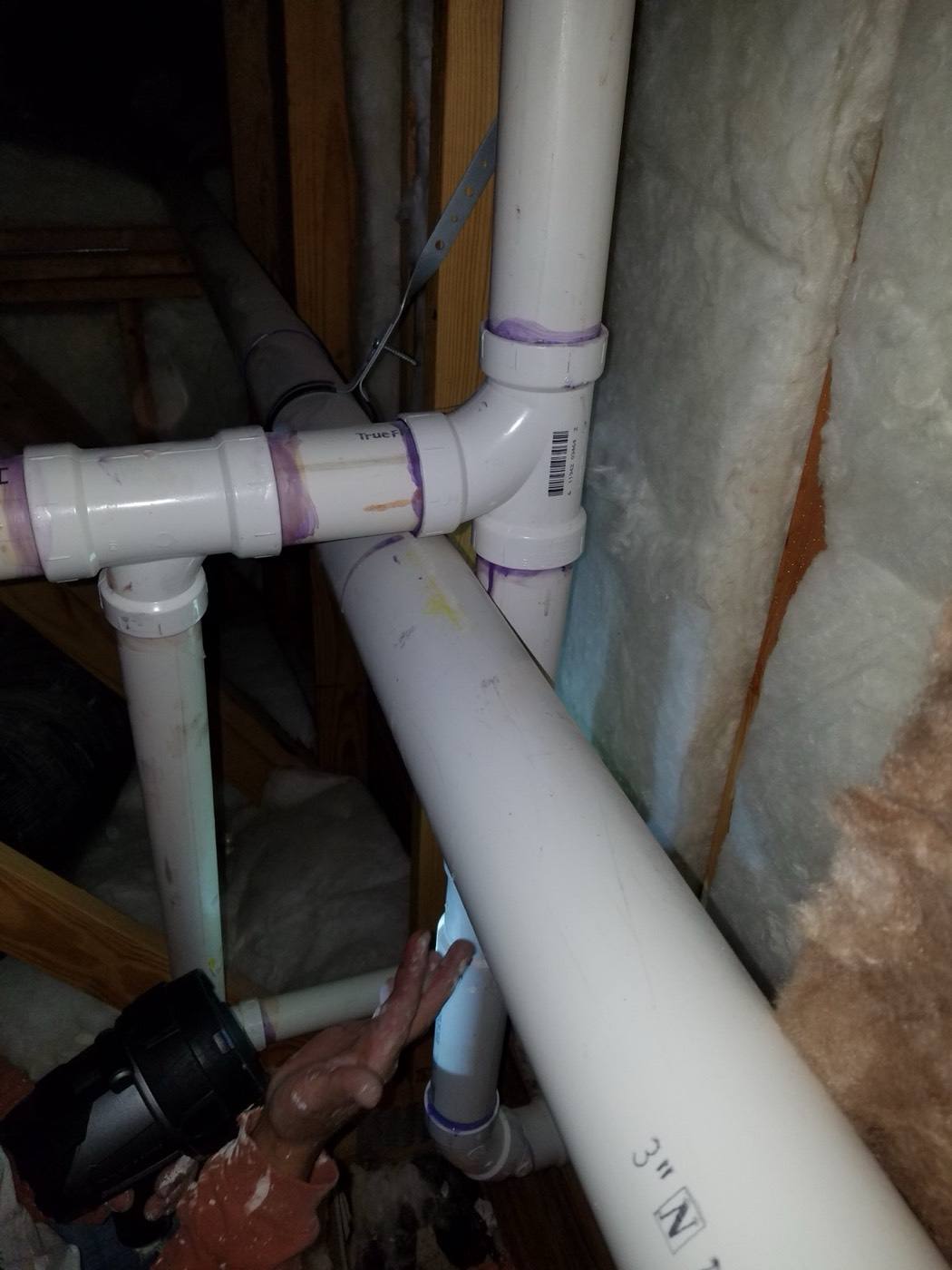 New PVC drain lines run through a crawlspace