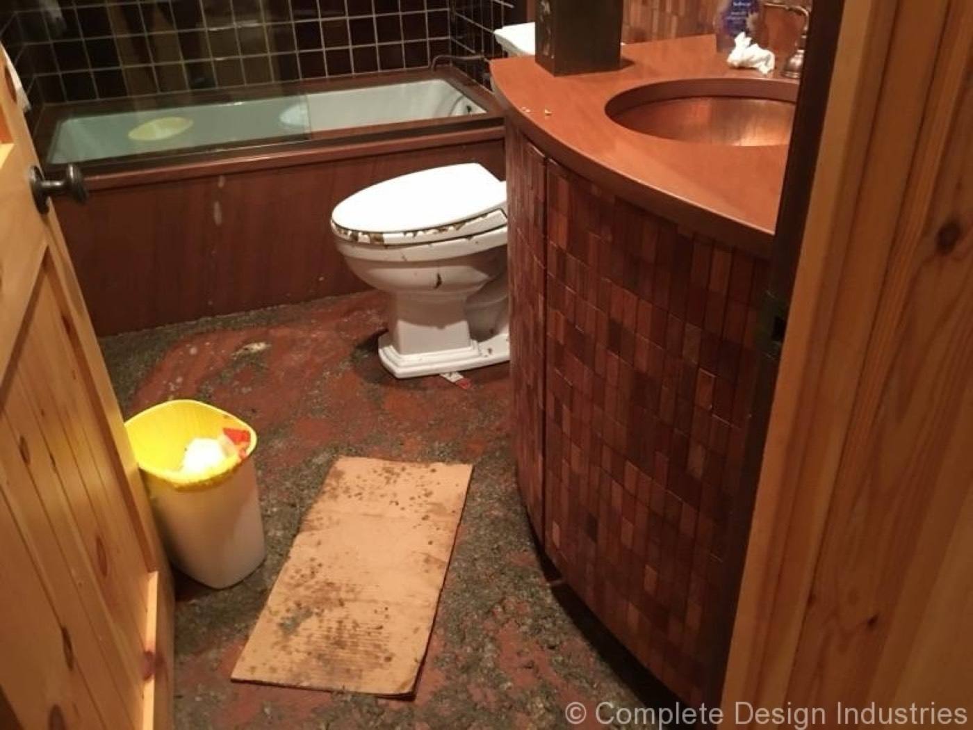Pine-paneled bathroom affected by a sewer backup